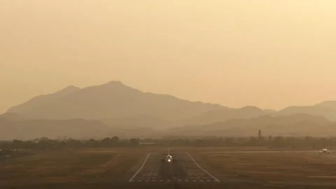 Aircraft rolling down the runway under an orange sky Video stock 136837447