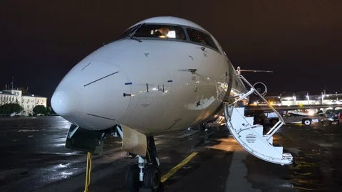 Aircraft stands in the parking lot on the airfield at night Stock Footage 90554174