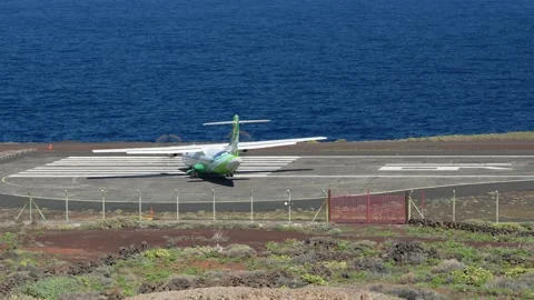 Aircraft turns at the runway edge in front of blue ocean Stock Footage 231574350