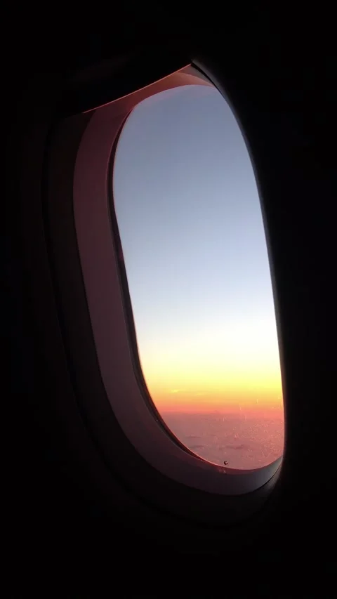 Aircraft window frame view of sunset above clouds. Stock Footage 345379417