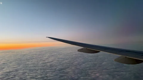 Aircraft wing above fluffy cloud cover at sunset. Stock Footage 304088336
