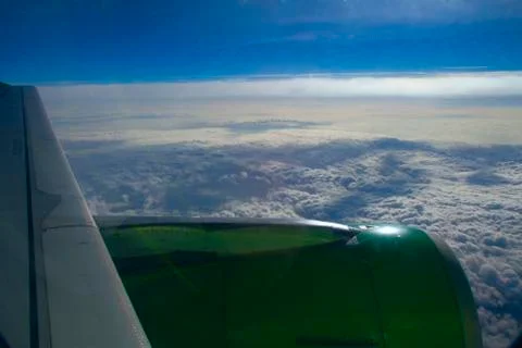 Aircraft wing on a background of clouds from the window. blue sky, white clou Stock Photos