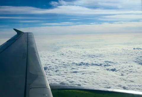 Aircraft wing on a background of clouds from the window. blue sky, white clou Stock Photos
