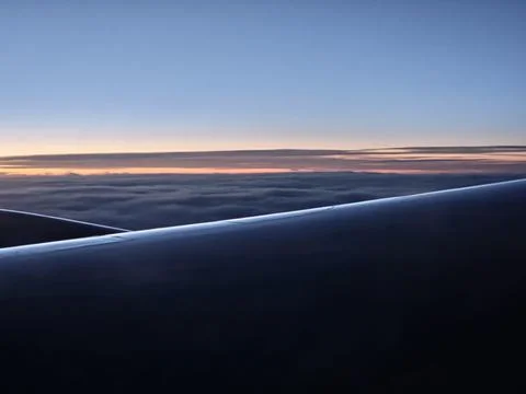 Aircraft Wing Over Cloud Layer at Colorful Morning Sunrise Stock Photos