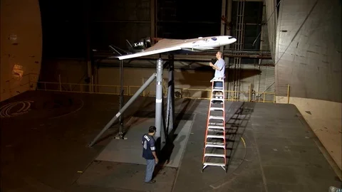 An aircrafts aerodynamics are tested in a wind tunnel. Stock Footage 123370674