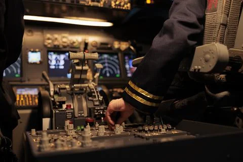 Aircrew member using control panel command on dashboard Foto stock