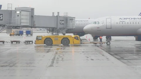 Airfield tractor moves the plane Stock Footage 129760169