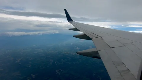 AIRLINE FLIGHT WINDOW CLOUDS SUNBEAMS RAIN STORM CLOUDS Stock Footage 92648489