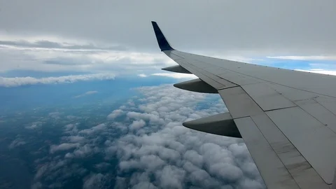 AIRLINE FLIGHT WINDOW CLOUDS SUNBEAMS RAIN STORM CLOUDS Stock Footage 92648510