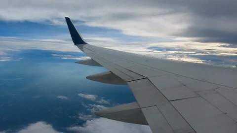 AIRLINE FLIGHT WINDOW CLOUDS SUNBEAMS RAIN STORM CLOUDS RAYS INTO STORM Stock Footage 92685800