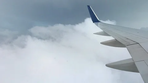 AIRLINE FLIGHT WINDOW CLOUDS SUNBEAMS RAIN STORM CLOUDS GX020540 PT1 Stock Footage 92695170