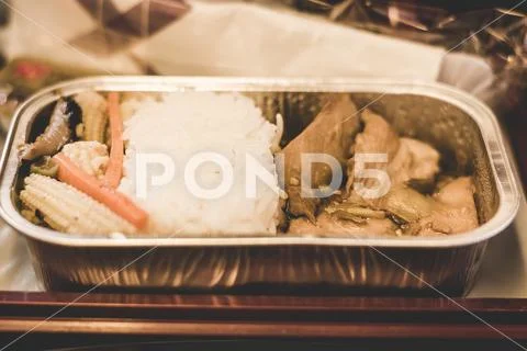 Airline inflight economy class meal served on a tray with steamed rice, soy s Stock Photos