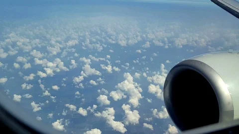 Airline passenger POV of jet engine and puffy clouds Stock Footage 93661031