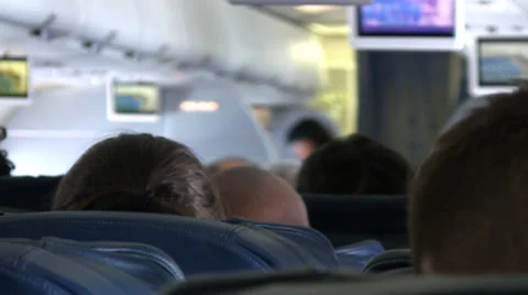 Airline passengers view overhead monitors while in flight.. Video stock 34354038
