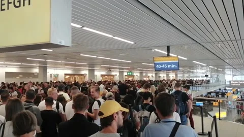 Airline passengers waiting in a queue inside Schiphol airport due to Stock Footage 205264855