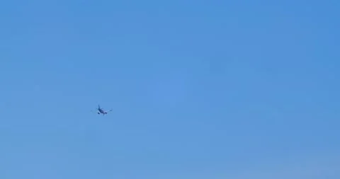 Airliner flies  across the blue cloudless sky. Video stock 166739448