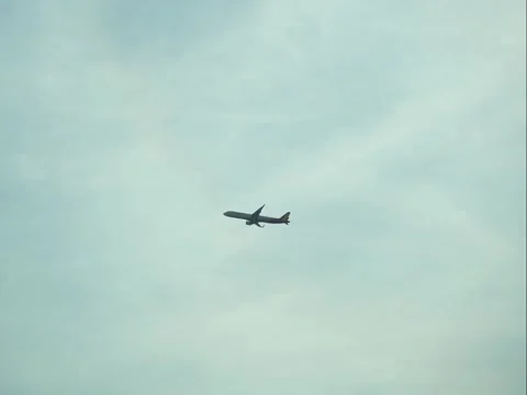 Airliner Flying High in the Sky Through Patches of White Clouds. Video stock 323159237