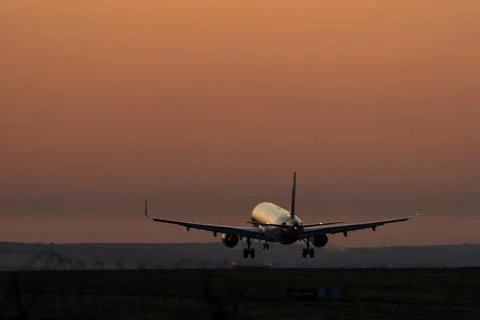 Airliner touching down at sunset, rear view Stock Photos