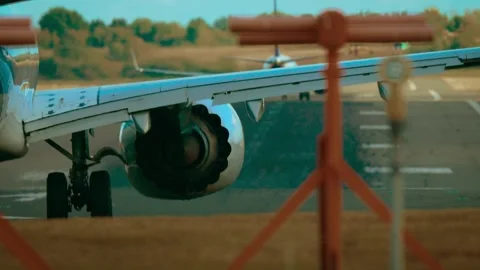 Airliner warming turbines on runway while another aircraft taking off in Stock Footage 328358192