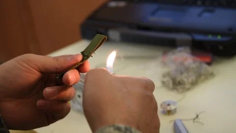 Airman burning excess thread from material with lighter in parachute workshop Video stock 104855472