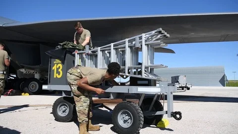 Airman cutting wire securing ladders on trailer Stock Footage 112125146