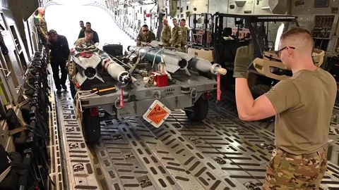 Airman directing loading of munitions onto C-17 Globemaster aircraft Stock Footage 273292656