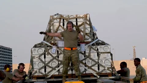 Airman directing while standing on cargo loader with pallets of explosives Video stock 256895822