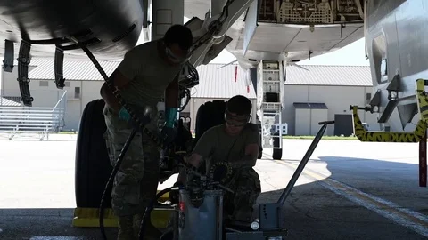 Airman fitting hoses to oil container beneath B2 Lancer Stock Footage 112125103