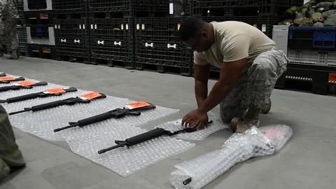 Airman packing rifle in bubble wrap inside warehouse for transportation Stock Footage 111998165