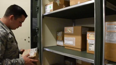 Airman placing parcel on shelf for distribution Stock Footage 111998018