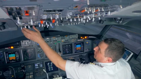 Airman is switching buttons on the upper side of the cockpit before the flight Stock Footage 90756273