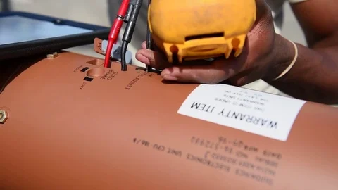 Airman testing electrical current during munitions building and loading program Stock Footage 83308842