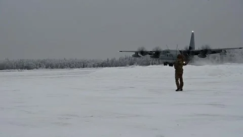 Airmen acknowledge U.S Marines KC-130J Hercules landing on snow covered airstrip Stock Footage 261018519