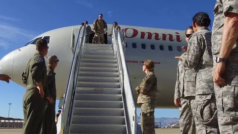 Airmen applaude as airmen returning from deployment emerge from aircraft Stock Footage 113394528
