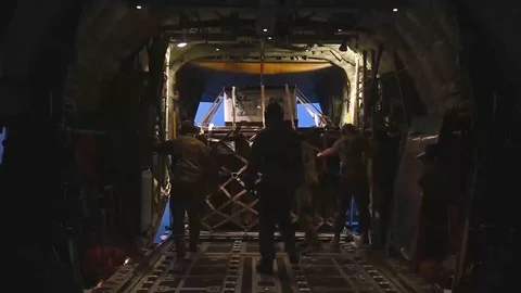 Airmen pulling cargo on to an aircraft and securing Stock Footage 114018005
