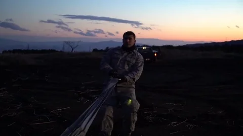 Airmen pulling parachute used in airdrop at dusk Stock Footage 84493316