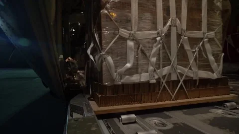 Airmen rolling pallet of cargo onto C-130J Hercules Stock-Footage 89609579