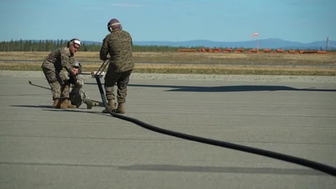 Airmen using clamp to deflate fuel hose during FARP Operations Stock Footage 108378380
