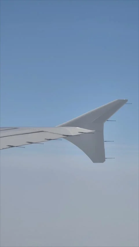Airplane above clouds blue sky plane wing view vertical video Stock Footage 282764481
