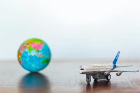Airplane and earth globe on a table. World travel concept Stock Photos