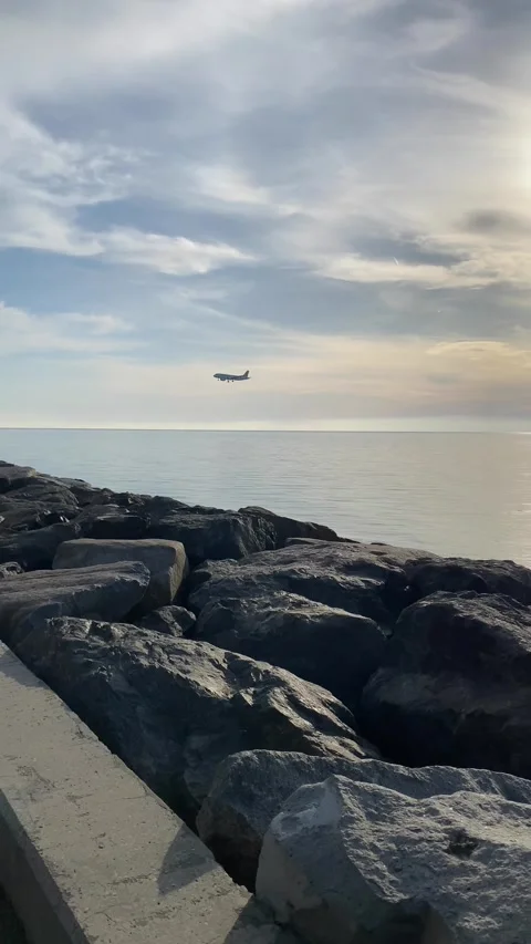 Airplane approaching for landing in slow motion over calm sea water Stock Footage 329304909