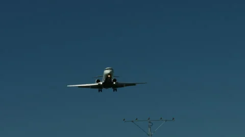 An airplane approaching in super slow motion against a blue sky Stock Footage 61649017