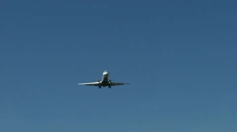 An airplane approaching in super slow motion against a blue sky Stock Footage 61649035