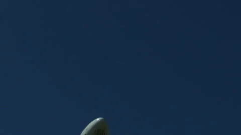 An airplane approaching in super slow motion against a blue sky Stock Footage 61649043