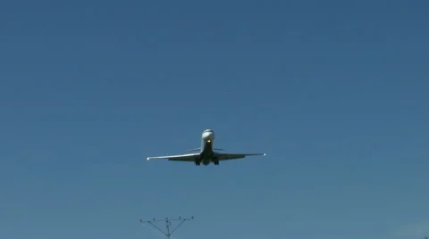 An airplane approaching in super slow motion against a blue sky Stock Footage 61649047