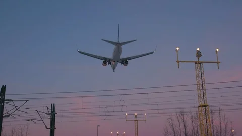 Airplane arrive late evening sunset sky behind landing guidance lights Video stock 99704539
