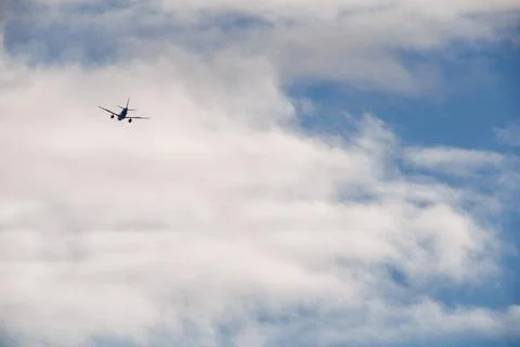 Airplane Ascending into the Clouds Stock Photos
