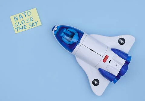 An airplane on a blue background with a note about a request from NATO to clo Stock Photos
