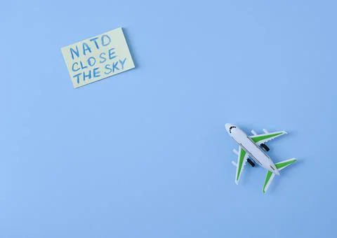 An airplane on a blue background with a note about a request from NATO to clo Foto stock