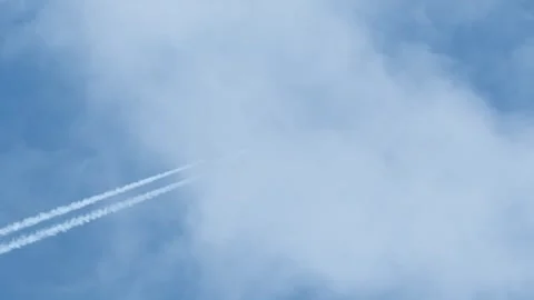 Airplane in the blue sky with white clouds and contrail. Stock Footage 309001413